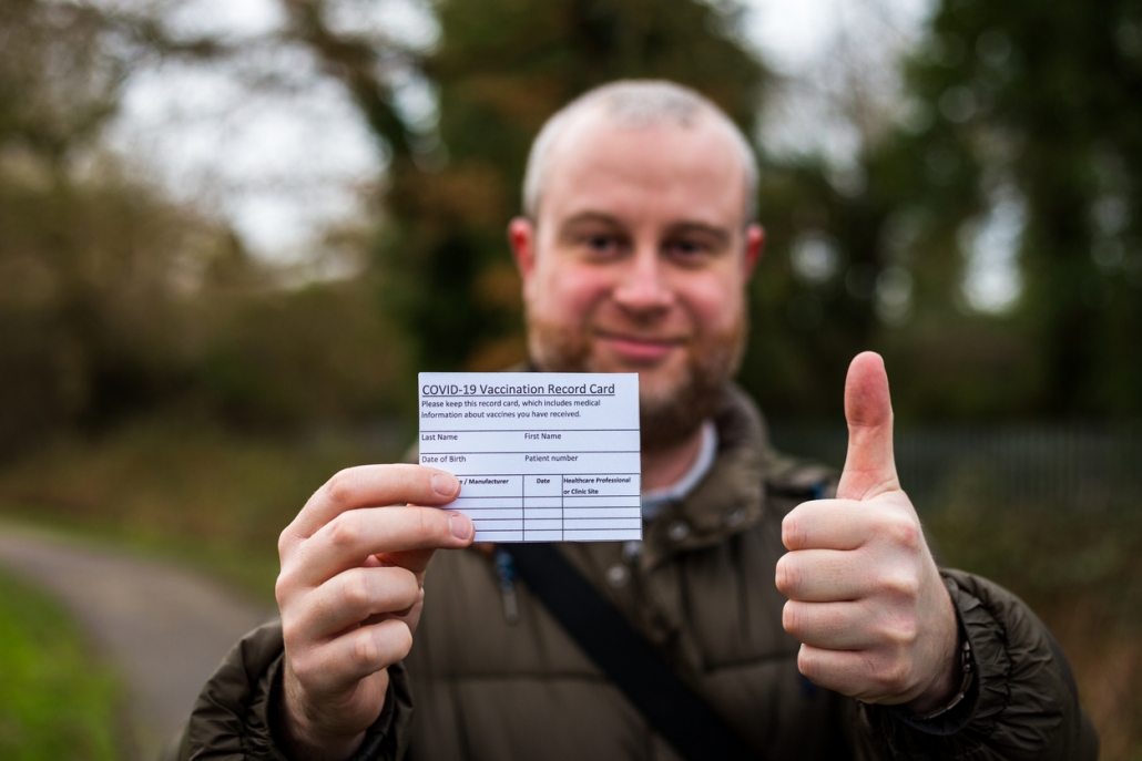 Man holding a vaccination card