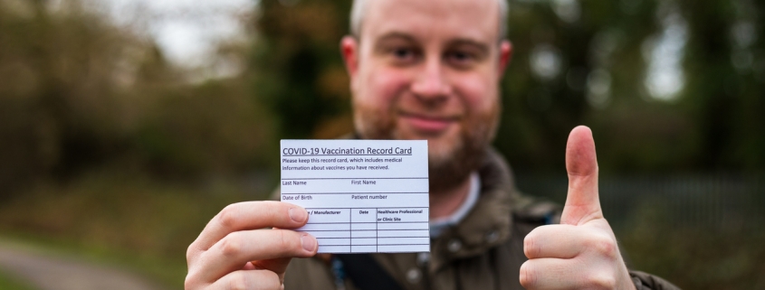Man holding a vaccination card