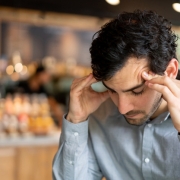 Man at a cafe having a headache