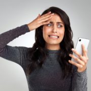 woman looking upset while looking at her cellphone